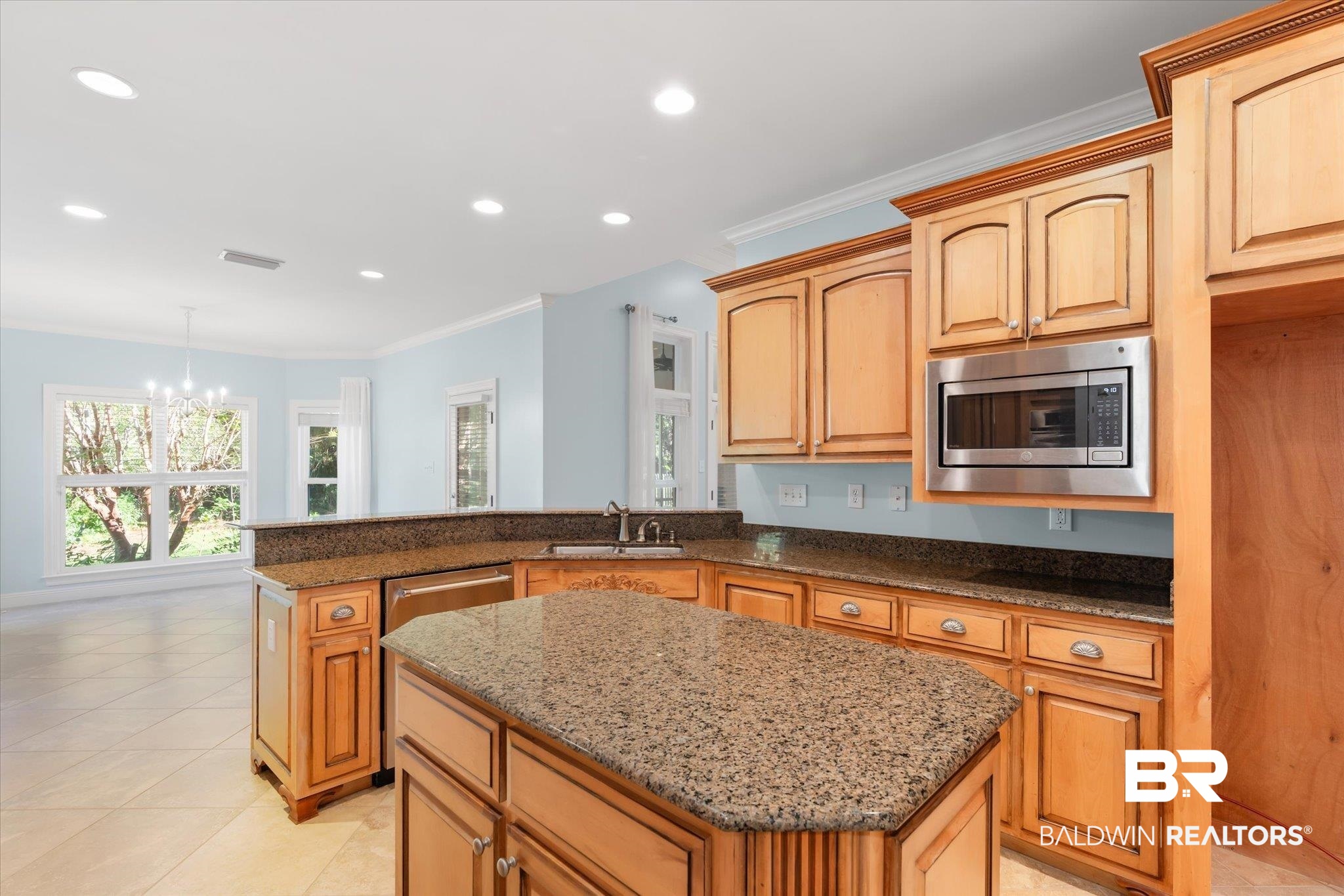 10730 Flagstone Drive Mobile, AL 36608 - Photo 7 of 20 Kitchen featuring sink, stainless steel microwave, a kitchen island, crown molding, and an inviting chandelier
