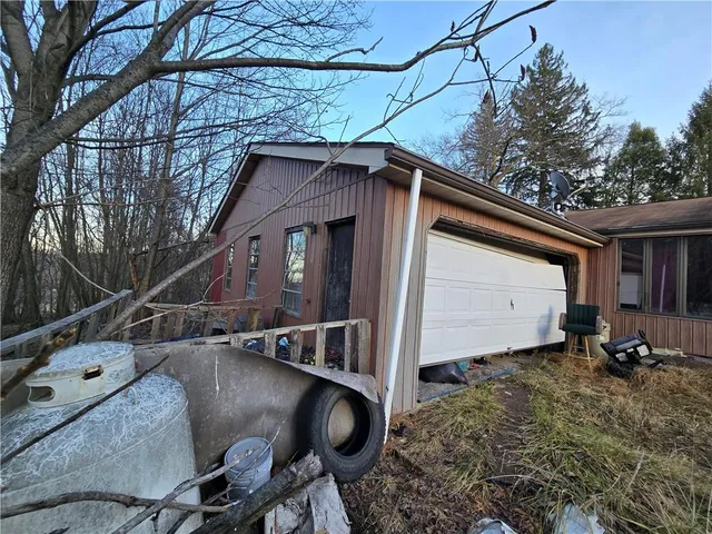 a backyard of a house with barbeque oven and large trees