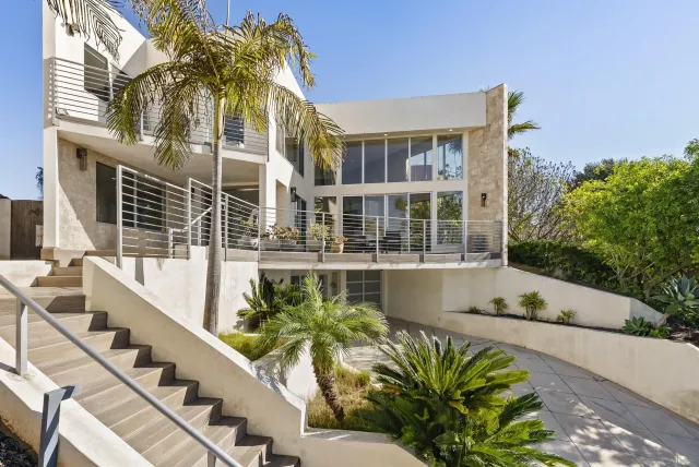 a front view of a house with glass windows and a table