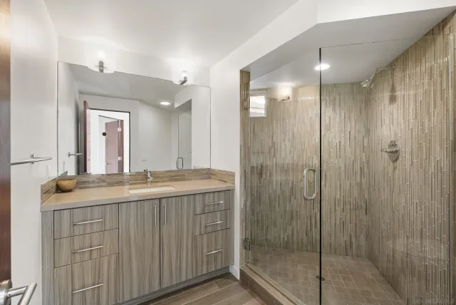 a bathroom with a shower and a glass door