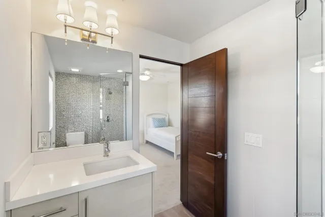 a bathroom with a granite countertop sink mirror and shower