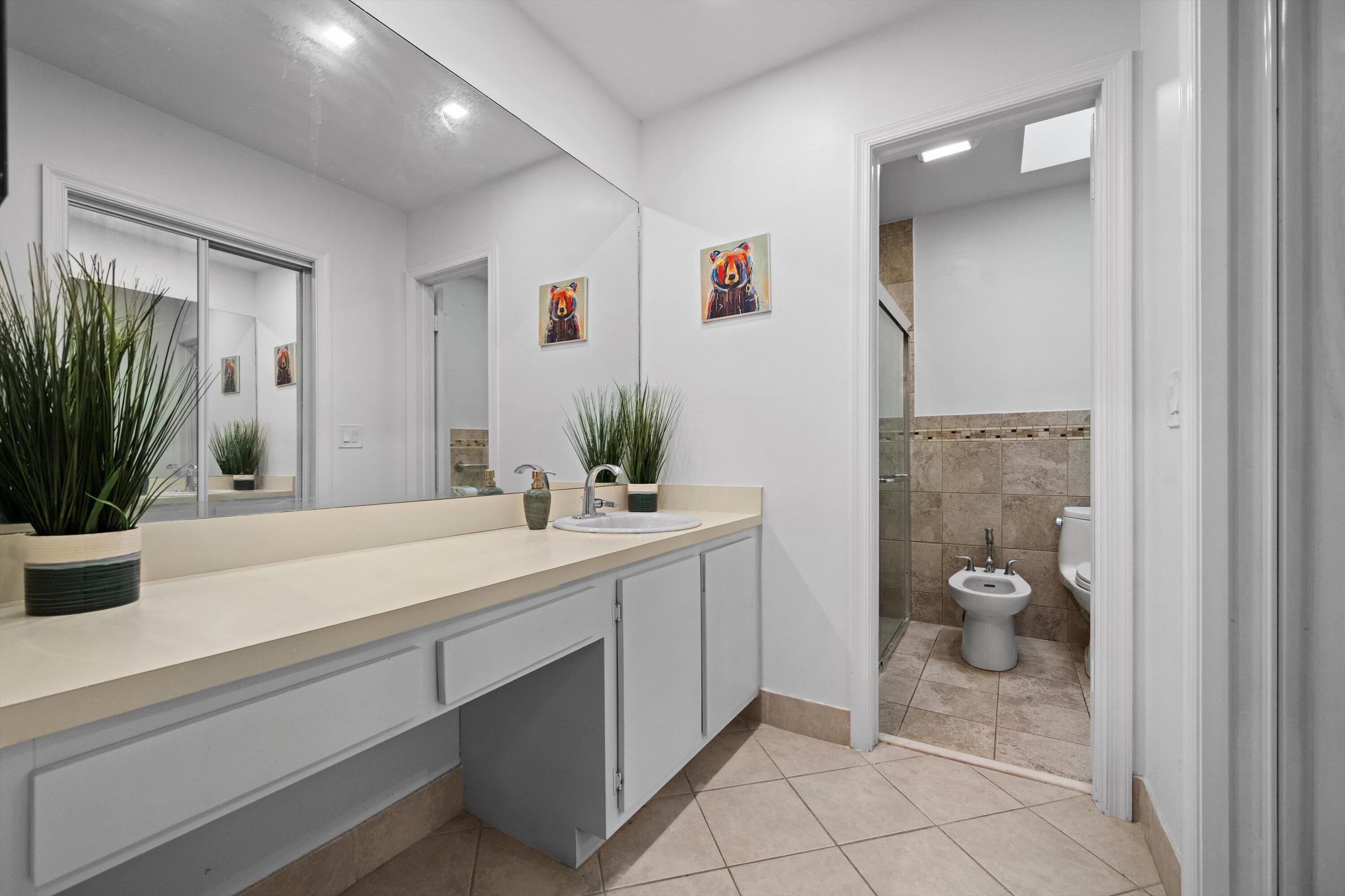 2 Ridge Pointe Drive, Unit A Boynton Beach, FL 33435 - Photo 15 of 24 a bathroom with a granite countertop sink a mirror and a shower