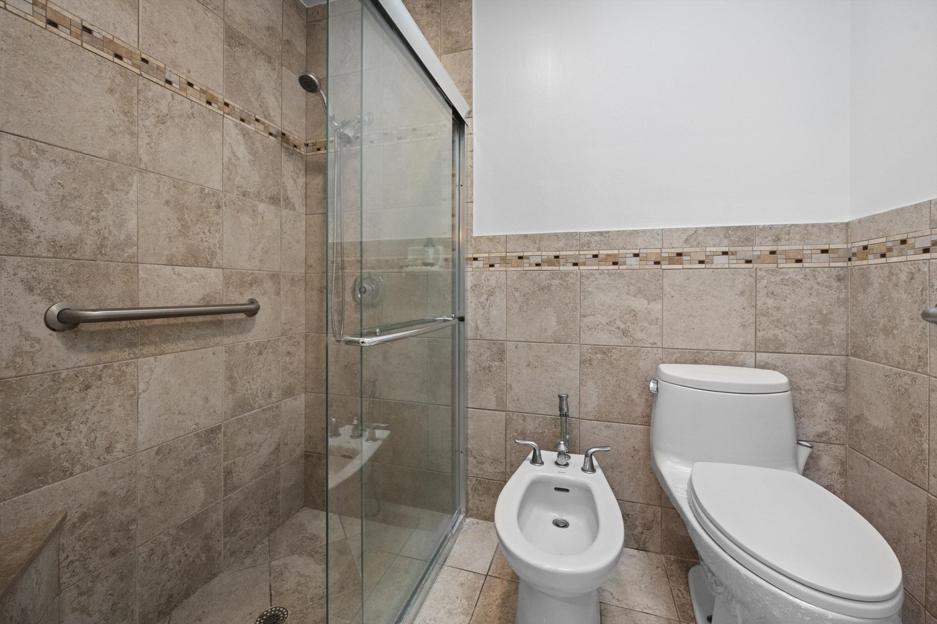 2 Ridge Pointe Drive, Unit A Boynton Beach, FL 33435 - Photo 16 of 24 a bathroom with a toilet and a shower