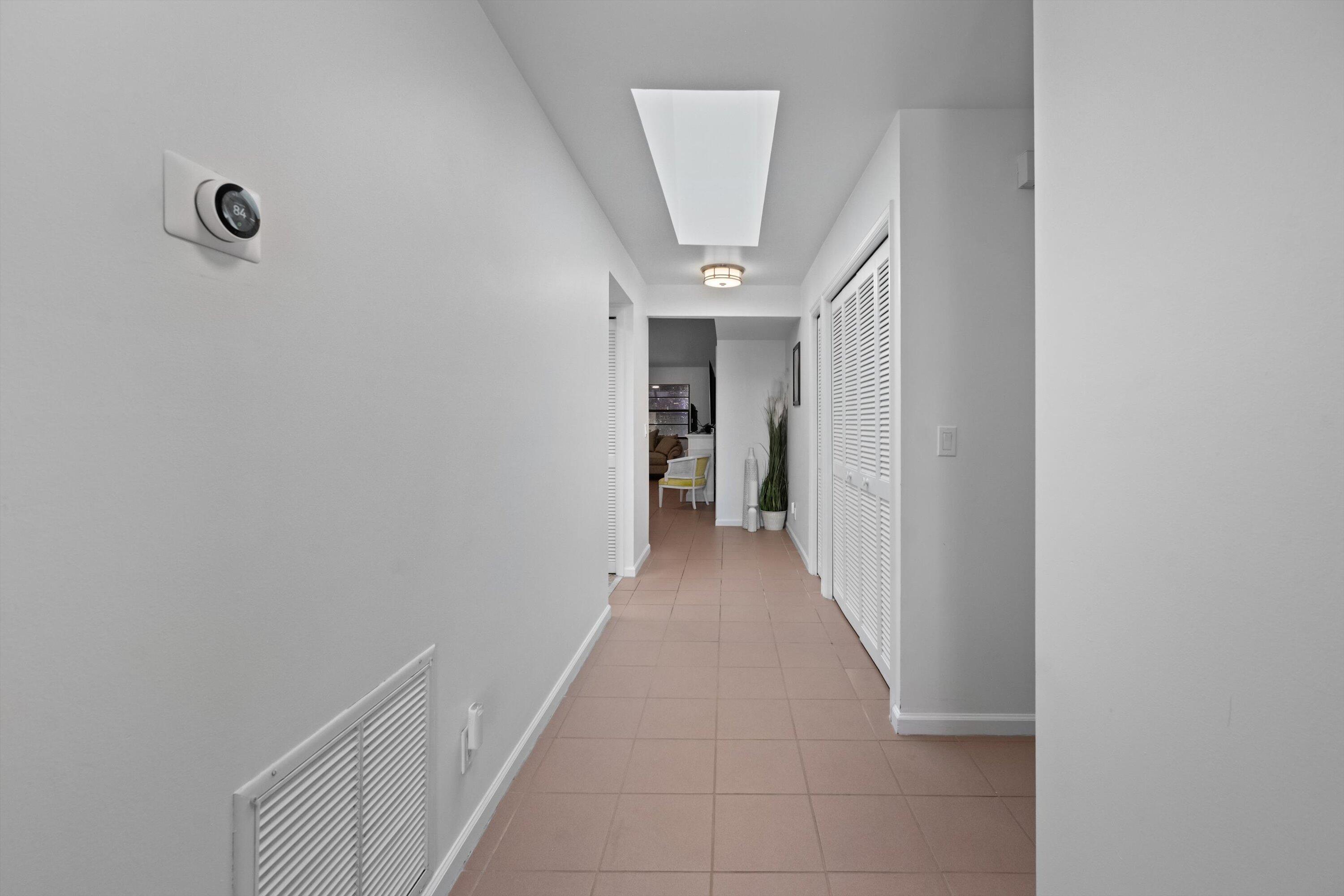 2 Ridge Pointe Drive, Unit A Boynton Beach, FL 33435 - Photo 8 of 24 a view of a hallway with wooden shelves