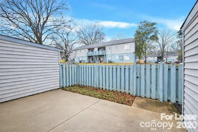 a view of a house with a wooden fence