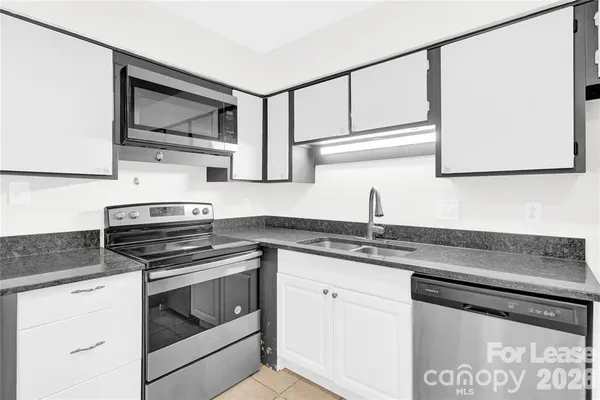 a kitchen with granite countertop cabinets stainless steel appliances and sink