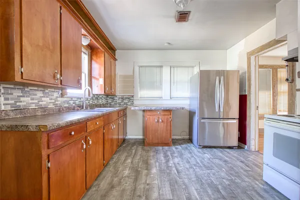 a kitchen with a refrigerator and wooden cabinets