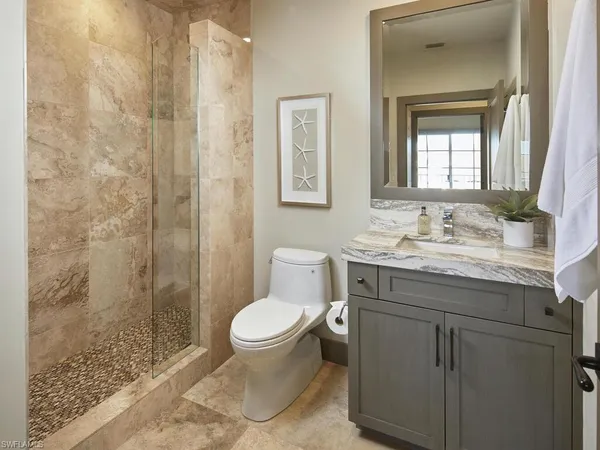 a bathroom with a granite countertop sink toilet and shower