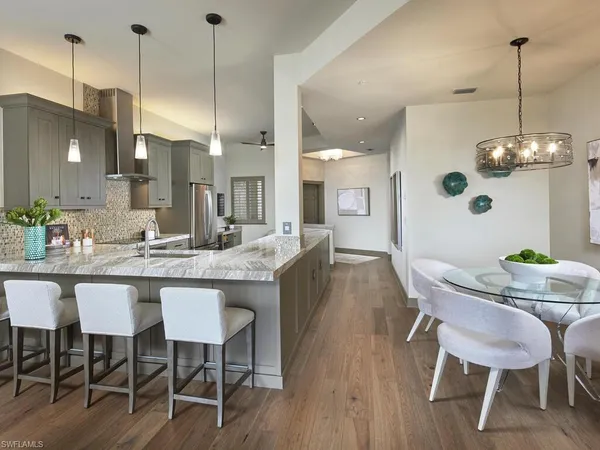a dining room filled chandelier and wooden floor