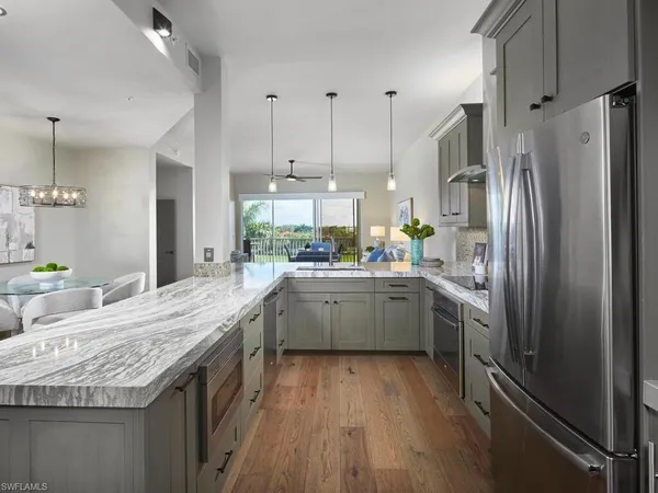 a kitchen with granite countertop a sink counter space stainless steel appliances and cabinets