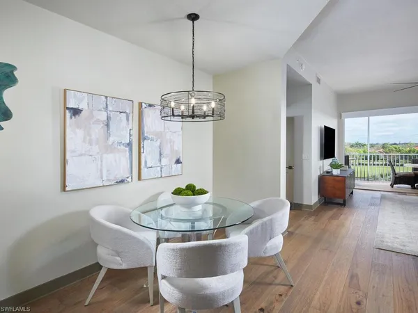 a dining room with furniture a chandelier and wooden floor