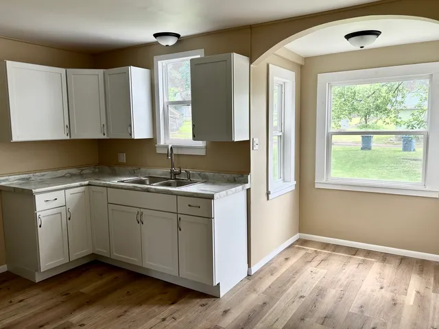 a kitchen with granite countertop wooden cabinets a sink and a window