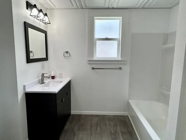 a bathroom with a sink a mirror and a bathtub