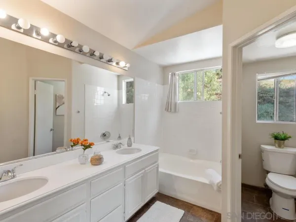 a bathroom with a sink double vanity granite toilet tub and shower