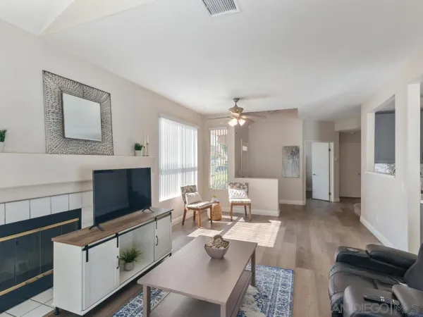 a living room with furniture a flat screen tv and kitchen view
