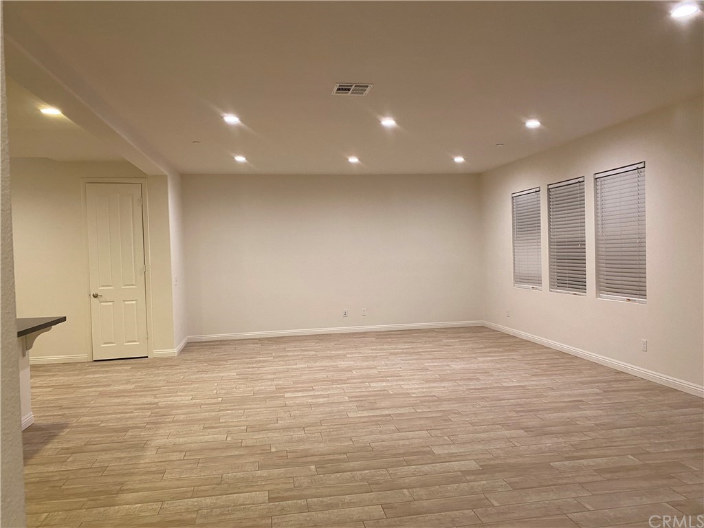 20648 Spring Street Riverside, CA 92507 - Photo 8 of 23 an empty room with wooden floor and windows