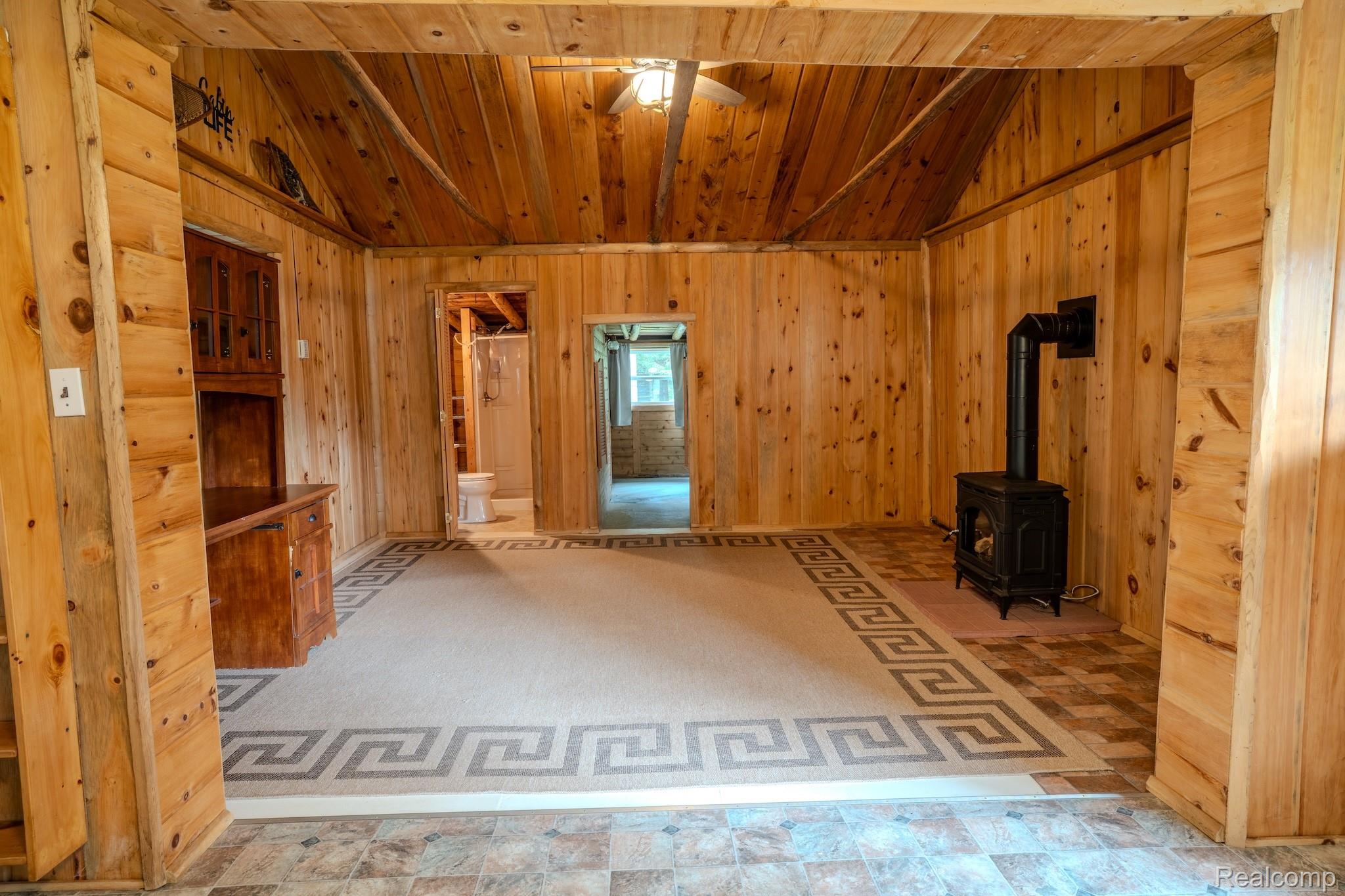 4350 Shrew Road Lincoln, MI 48742 - Photo 12 of 32 Interior room featuring extensive wood paneling and a vaulted wood-finish ceiling