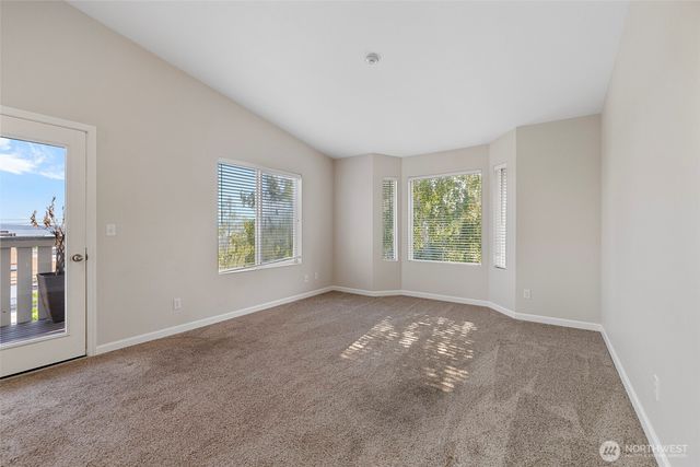 a view of a big room with windows and chandelier fan