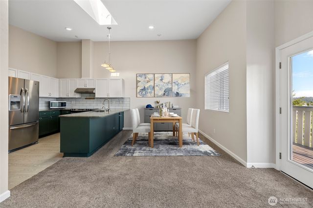 a kitchen with stainless steel appliances granite countertop a stove a sink and a refrigerator