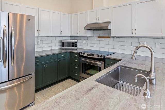 a kitchen with stainless steel appliances granite countertop a refrigerator sink and cabinets