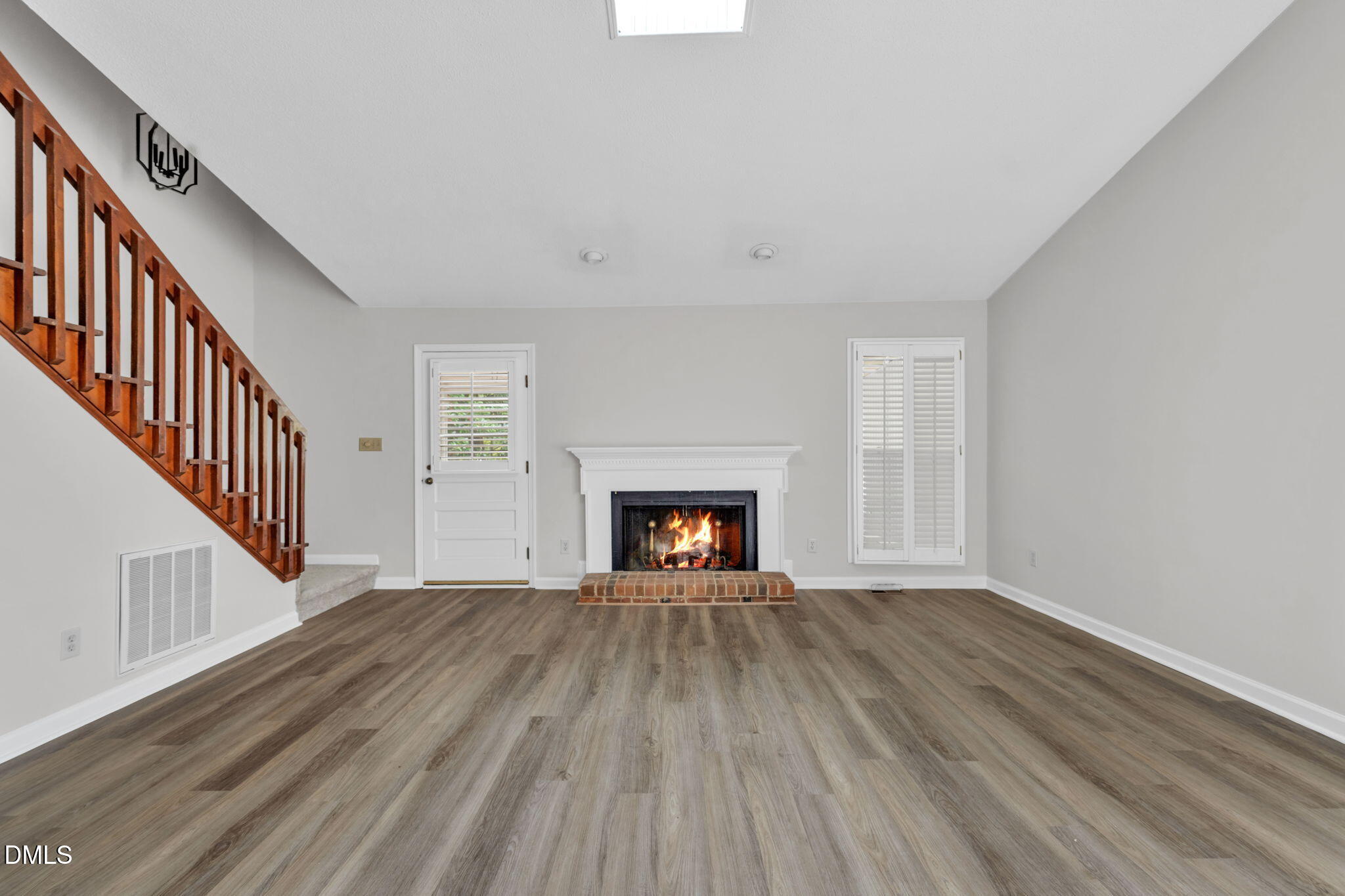 2860 Rue Sans Famille Raleigh, NC 27607 - Photo 3 of 40 a view of a livingroom with wooden floor a fireplace and windows
