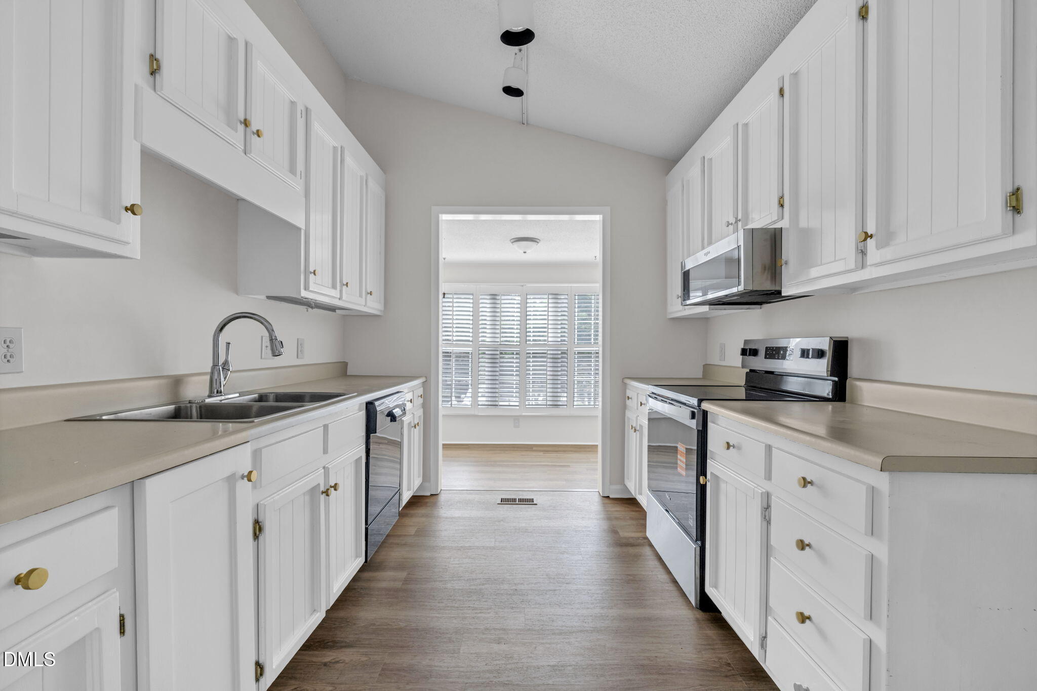 2860 Rue Sans Famille Raleigh, NC 27607 - Photo 9 of 40 a kitchen with white cabinets sink and stove