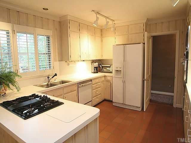 2605 Wells Avenue Raleigh, NC 27608 - Photo 6 of 12 Open, bright kitchen has light cabinets and paneling, convection oven, lots of counterspace, peninsula with gas range and Kentile flooring. Kitchen