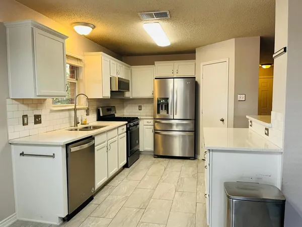 a kitchen with stainless steel appliances a refrigerator sink and cabinets