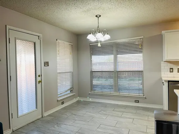 a view of a livingroom with a chandelier curtains and wooden floor