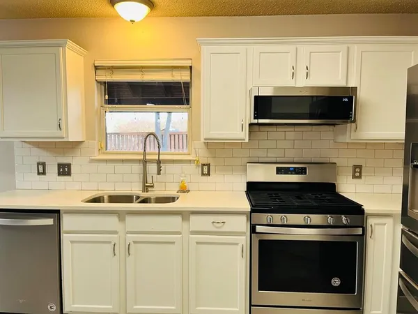 a kitchen with cabinets stainless steel appliances and a sink