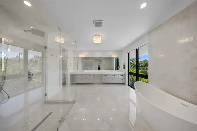 an aerial view of ocean and residential houses with outdoor space