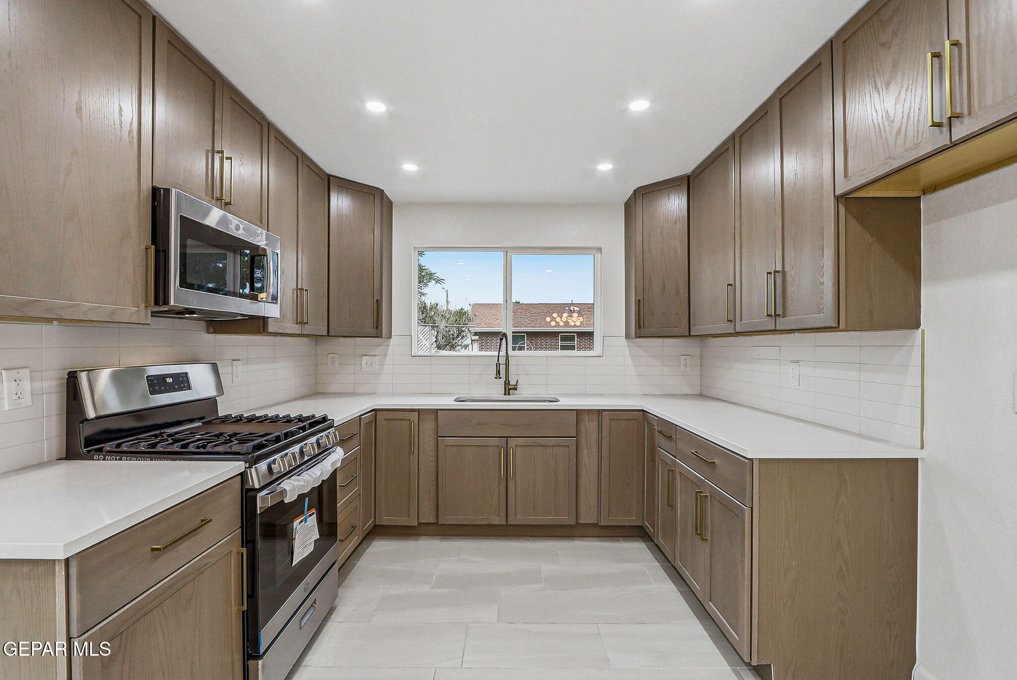 709 Frontera Road El Paso, TX 79922 - Photo 13 of 41 a kitchen with stainless steel appliances granite countertop wooden cabinets a sink and a stove