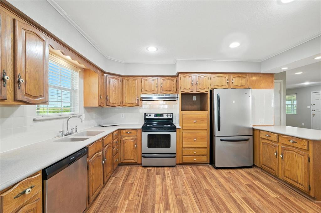 358 Wright Road Waxahachie, TX 75167 - Photo 22 of 38 a kitchen with stainless steel appliances granite countertop a refrigerator a sink dishwasher a stove with wooden cabinets and floor