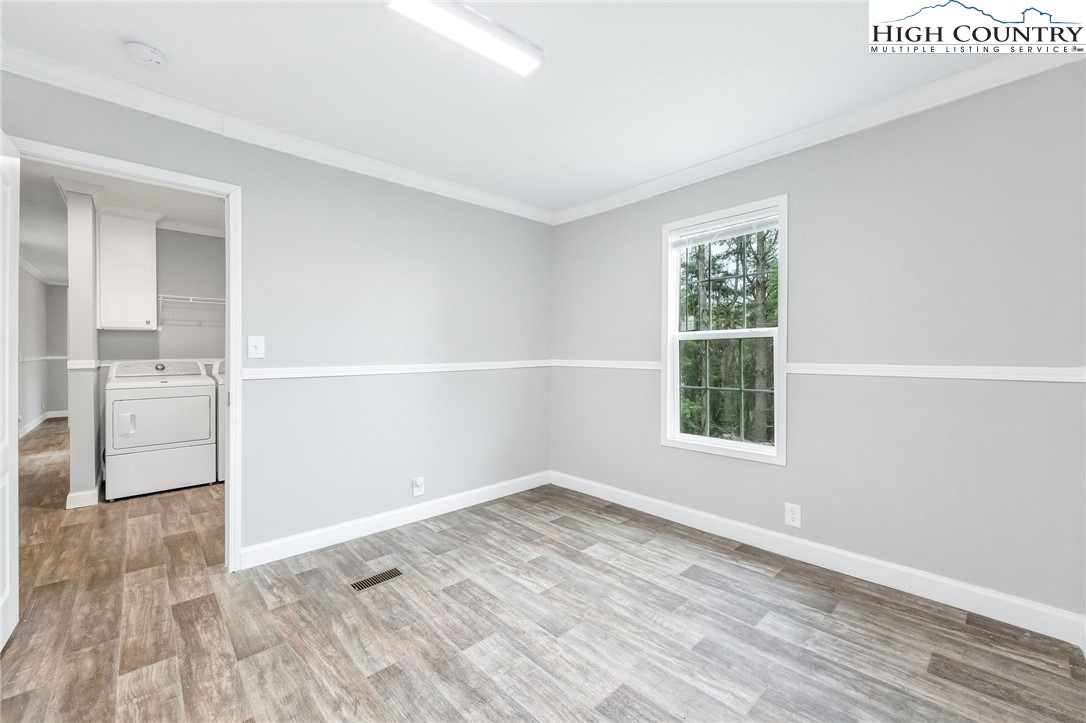 939 Don Bare Road Jefferson, NC 28640 - Photo 16 of 22 an empty room with wooden floor and windows