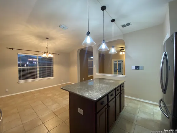 a kitchen with a sink a faucet a chandelier and living room view