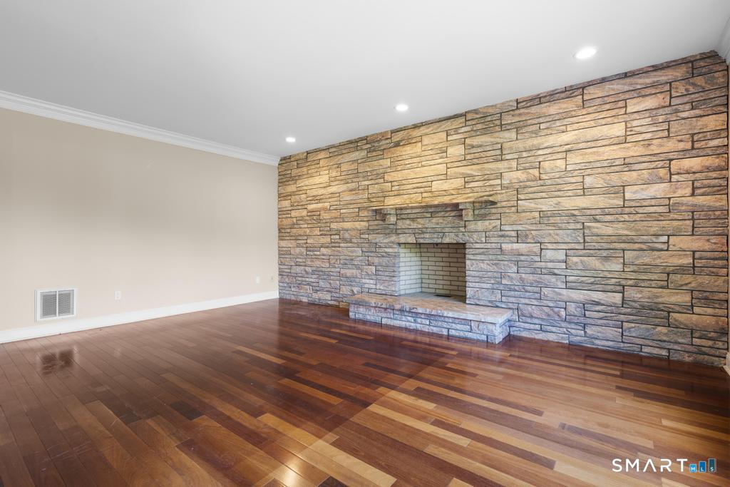 49 Partridge Lane Middletown, CT 06457 - Photo 6 of 39 a view of an empty room with wooden floor and a fireplace