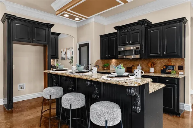 a kitchen with granite countertop a table chairs stove and cabinets