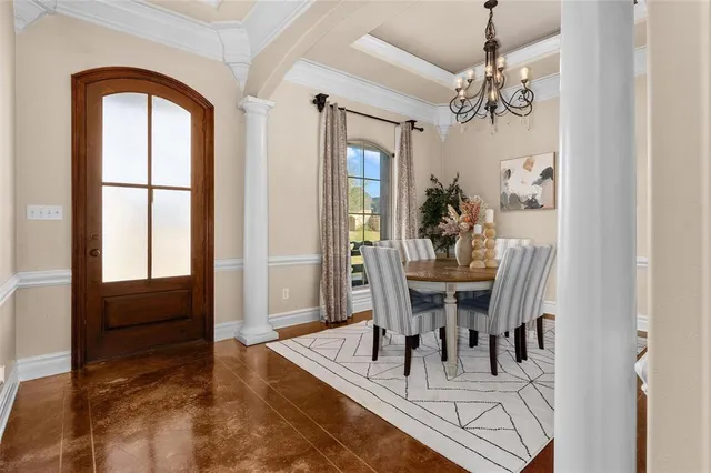 a view of a dining room with furniture a chandelier and wooden floor