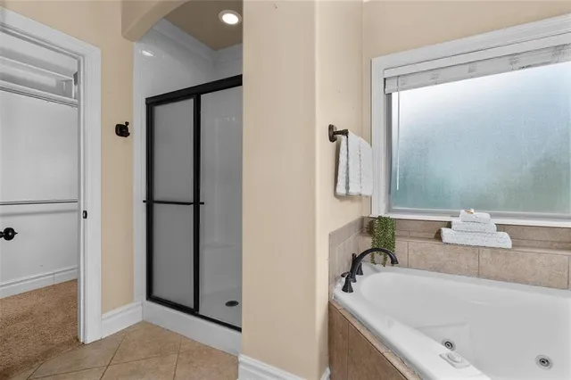 a bathroom with a tub sink and mirror