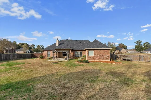a view of a house with a yard and a large tree