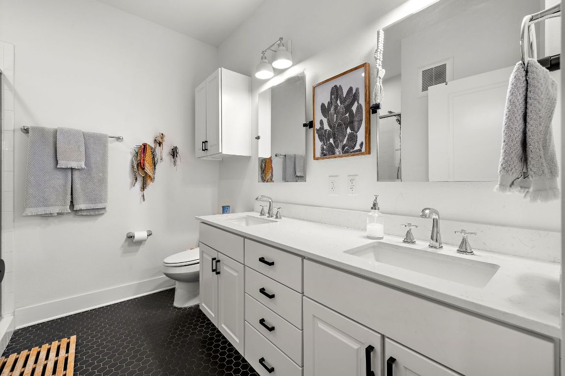 4704 Sunset Trail, Unit 1101 Austin, TX 78745 - Photo 14 of 23 Bathroom featuring a stall shower and double vanity