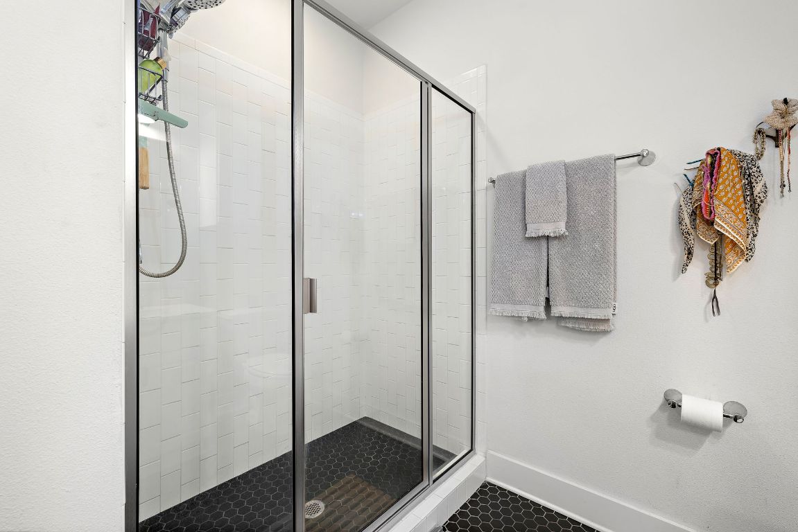 4704 Sunset Trail, Unit 1101 Austin, TX 78745 - Photo 15 of 23 Full bathroom featuring a stall shower and baseboards