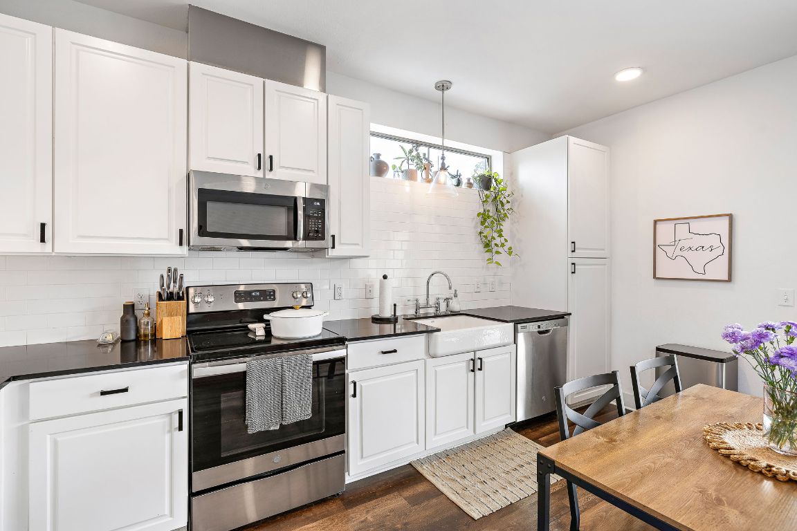4704 Sunset Trail, Unit 1101 Austin, TX 78745 - Photo 10 of 23 Kitchen featuring appliances with stainless steel finishes, decorative light fixtures, white cabinets, and recessed lighting