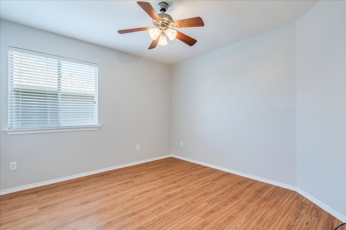1507 Davis Mountain Loop Cedar Park, TX 78613 - Photo 20 of 30 Guest bedroom featuring wood laminate flooring, a ceiling fan and faux wood blinds.