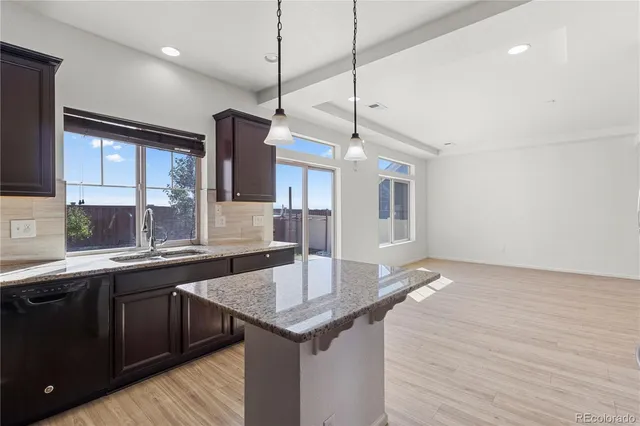 a kitchen with stainless steel appliances granite countertop a refrigerator a stove a sink and a microwave