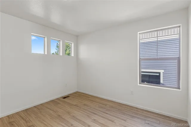 a view of an empty room with wooden floor