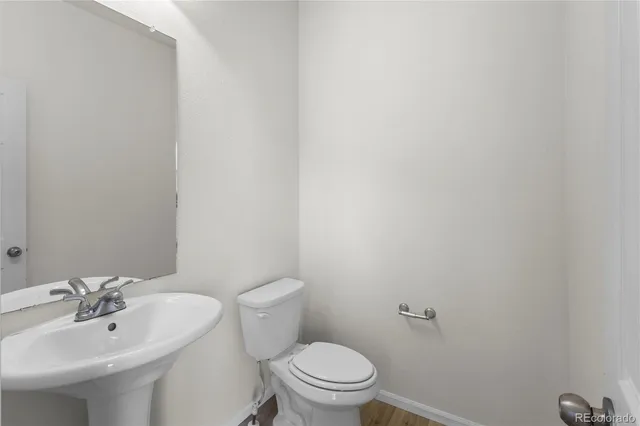 a view of living room kitchen with stainless steel appliances wooden floor dining table and chairs