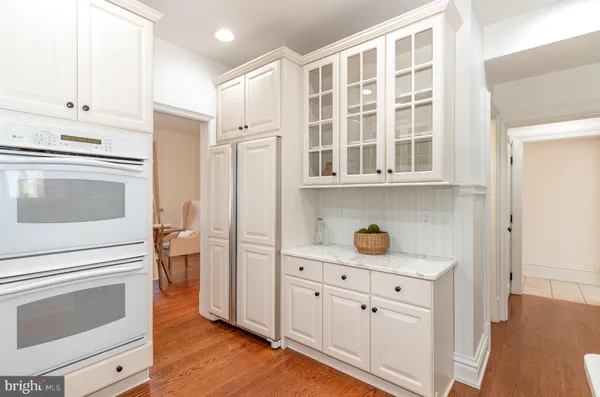 a kitchen with cabinets and wooden floor