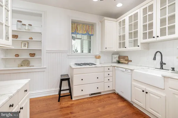 a kitchen with granite countertop white cabinets and sink
