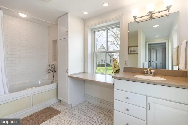 a bathroom with a granite countertop sink mirror bathtub and shower